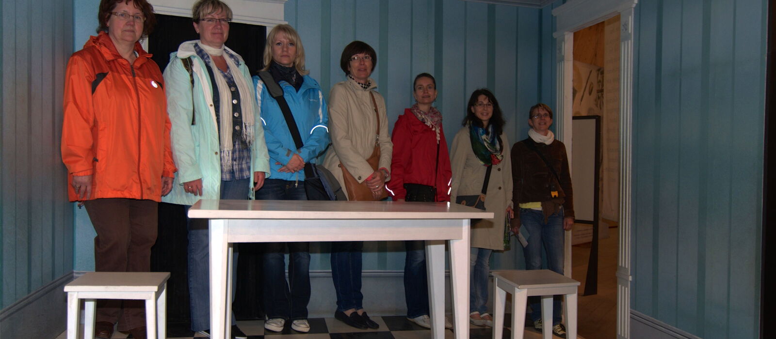Besuchergruppe in einer historisch eingerichteten Stube eines Museums