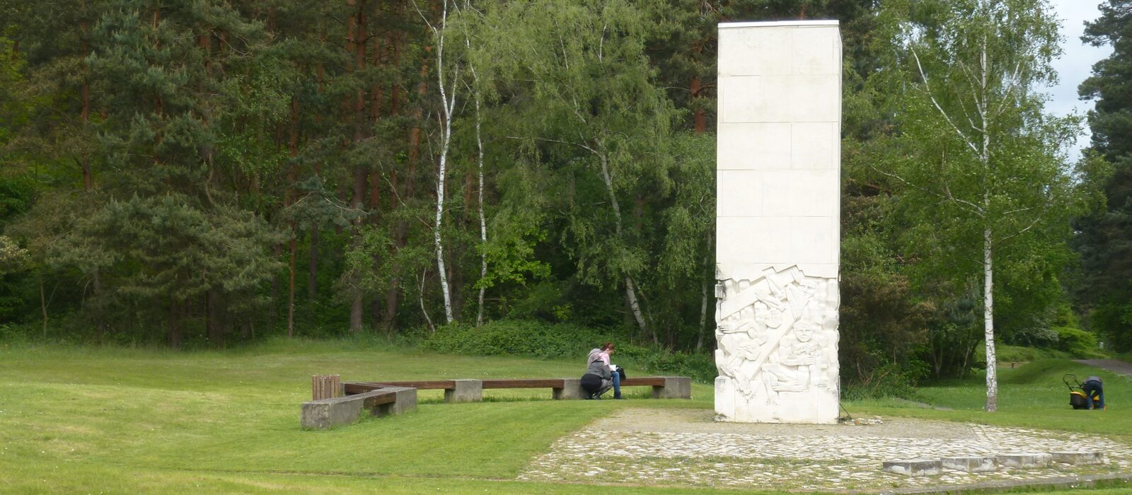 Gedenkstele mit Relief auf einer Waldlichtung